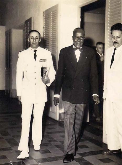 Louis Tècle Courbain de paisano junto al gobernador de la colonia, ceremonia oficial